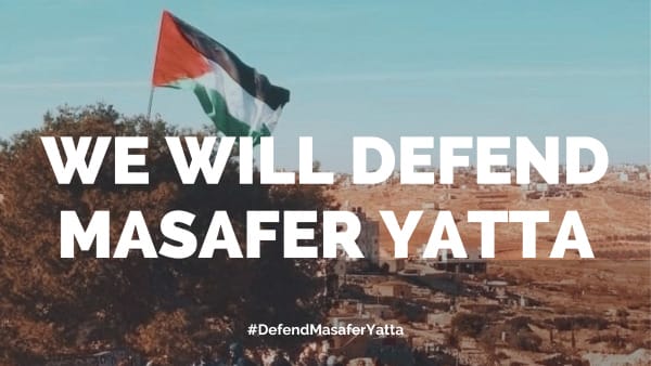 We Will Defend Masafer Yatta, in front of village with Palestinian flag